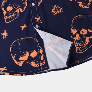 Close-up detail of Halloween shirt featuring orange skull and moth prints on navy blue