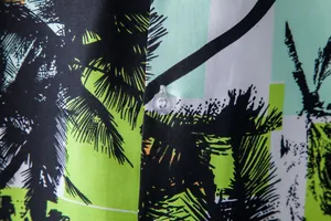 Macro detail of a men's Hawaiian short sleeve shirt with palm tree print and clear button