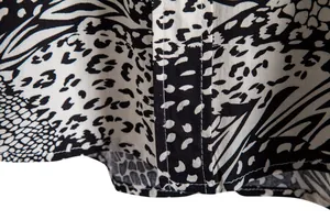 Macro detail view of black and white leopard print fabric on a men's casual shirt