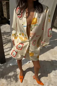 Detail shot of elegant V-neck printed dress with colorful sun and heart patterns