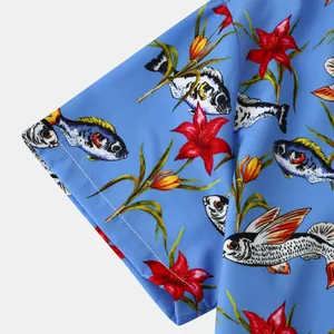 Close-up detail of men's blue beach shirt featuring floral and fish patterns