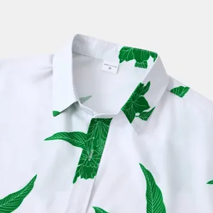 Détail du col d'une chemise hawaïenne blanche avec imprimé de feuilles vertes