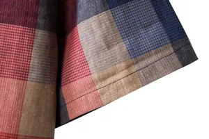 Close-up of the sleeve cuff on a men's plaid linen cotton casual shirt showing texture.