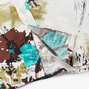 Detailed close-up of the fabric texture and button on this men's Hawaiian print shirt