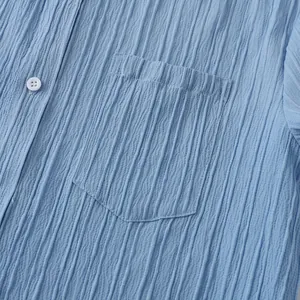 Detalle de una camisa de manga corta arrugada azul claro para hombre con un bolsillo.