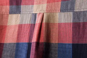 Detailed close-up of the back pleat on a red and blue plaid cotton linen casual shirt for men.