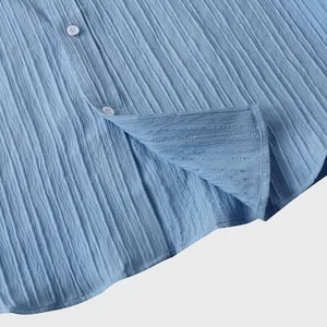 Detalle del tejido texturizado azul claro de una camisa de manga corta para hombre con botones