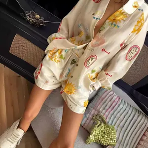Detailed view of a boho print satin pajama set featuring sun and heart motifs in cream