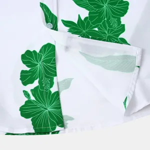 Vue détaillée de l'imprimé floral hibiscus vert et des coutures sur chemise hawaïenne