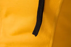 Gros plan sur le tissu jaune respirant et le cordon de serrage noir d'un gilet de sport