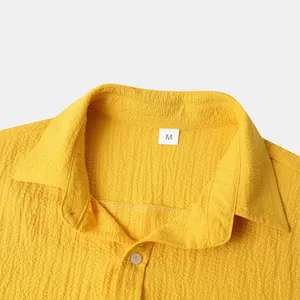Close-up detail of a yellow men's shirt collar showing textured fabric and size M tag