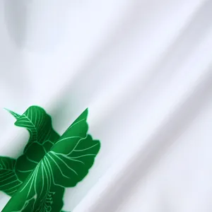 Gros plan du tissu de chemise hawaïenne blanche avec imprimé floral hibiscus vert vif