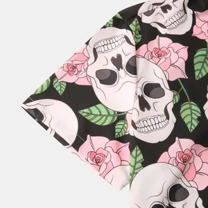 Close-up macro detail of skull and pink rose floral print on black men's Hawaiian shirt fabric