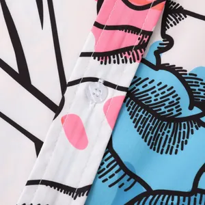 Macro detail showing the button and pop art pattern of a men's casual beach shirt.