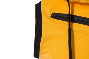 Détail de la veste de sport jaune montrant la poche zippée et la texture du tissu