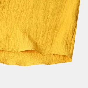Macro view of bright yellow textured fabric hem on a casual summer men's shirt.