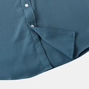 Close-up of waffle texture and buttons on men's blue summer casual shirt hem