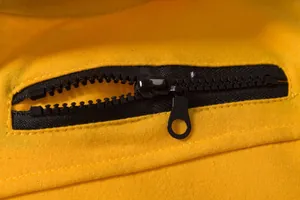 Gros plan détaillé d'une fermeture éclair noire sur un gilet de sport jaune vif