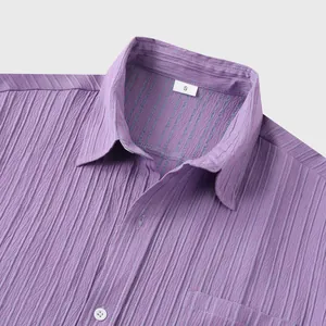 Vista detallada de la textura plisada púrpura y el cuello de una camisa de hombre