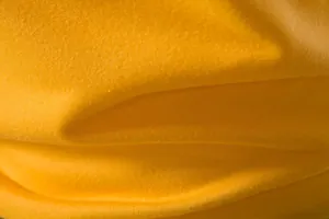 Vue macro de la texture du tissu en maille jaune respirant du gilet de sport homme