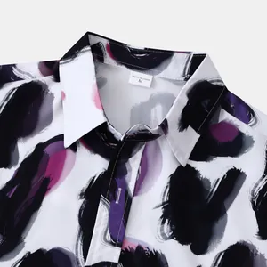 Détail du col d'une chemise pour homme avec un motif abstrait de traits violets.