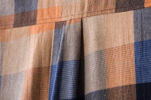 Macro detail of breathable linen-blend plaid fabric showing back pleat and stitching.