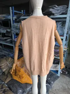 Detailed back view of a peach knitted sleeveless vest with side pockets on a mannequin