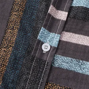 Close-up detail of multi-colored striped fabric and white button on a men's casual shirt