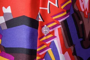 Close-up macro detail of vibrant ethnic print fabric and clear button on Hawaiian shirt