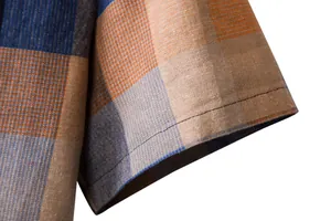 Detail shot of men's plaid linen shirt sleeve showing stitching and fabric texture