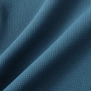 Macro view of blue waffle-textured fabric used in casual men's summer shirts