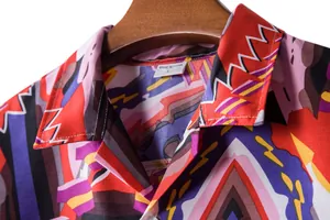 Close-up of vibrant tribal geometric print on a men's Hawaiian vacation shirt collar.