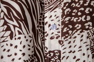 Macro view of the detailed animal print pattern and translucent button on a shirt