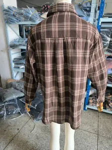 Vista posteriore dettagliata di una camicia a quadri marrone oversize da donna.