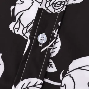 Macro close-up of a black and white rose floral print shirt showing button and stitching detail