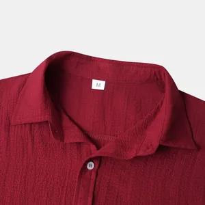 Macro detail view of burgundy crinkle fabric men's shirt collar and size M label tag