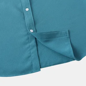 Macro detail of breathable blue waffle knit fabric on summer men's casual short sleeve shirt