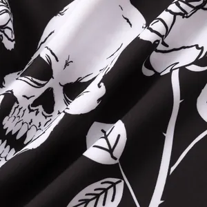 Macro detail of Halloween shirt fabric featuring black and white skull and vine prints.
