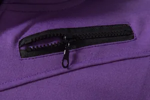 Vue détaillée d'une poche avec fermeture éclair noire sur un gilet de sport violet pour homme