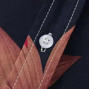 Dettaglio del bottone bianco e delle cuciture su camicia a fiori da uomo