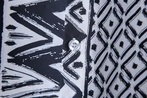 Close-up detail of ethnic black and white print fabric with a transparent button.