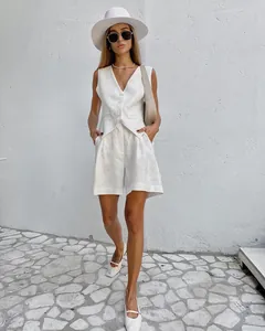 Detailansicht eines weißen Leinen-Westen-Sets, gestylt mit sommerlichen Accessoires.
