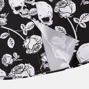 Detailed macro view of the intricate skull and rose print on a black Halloween shirt