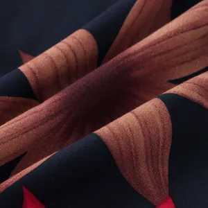 Dettaglio macro della trama del tessuto traspirante con stampa floreale marrone e rossa su nero