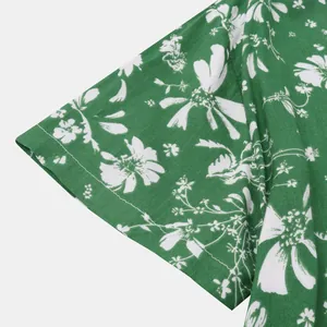 Detailaufnahme des Ärmels eines grünen Hawaiihemdes mit hübschen weißen Blumenmustern