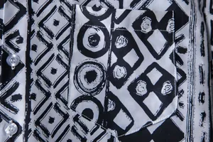 Close-up of chest pocket and black and white ethnic print on men's Hawaiian shirt