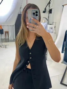 Selfie dans un miroir d'un ensemble gilet et short en lin noir dans un studio photo.