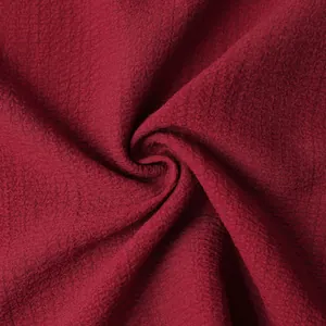 Detailed macro view showing the textured burgundy seersucker fabric of a men's summer shirt