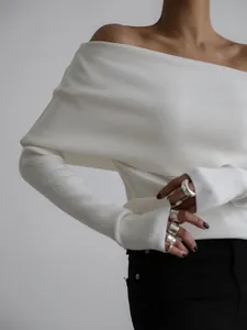 Detailed view of a white off-the-shoulder rib-knit sweater showing fabric texture and fit