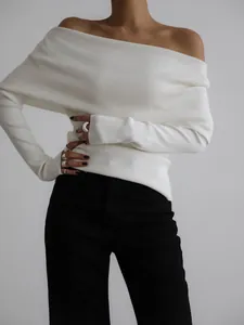 Close-up of white off-the-shoulder ribbed knit sweater showing fabric texture and fit
